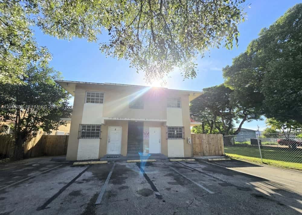 A two-story apartment building with a parking lot in front and a wooden fence — 2835 NW 22nd Ave, Miami FL 33142, MIAMI, FL