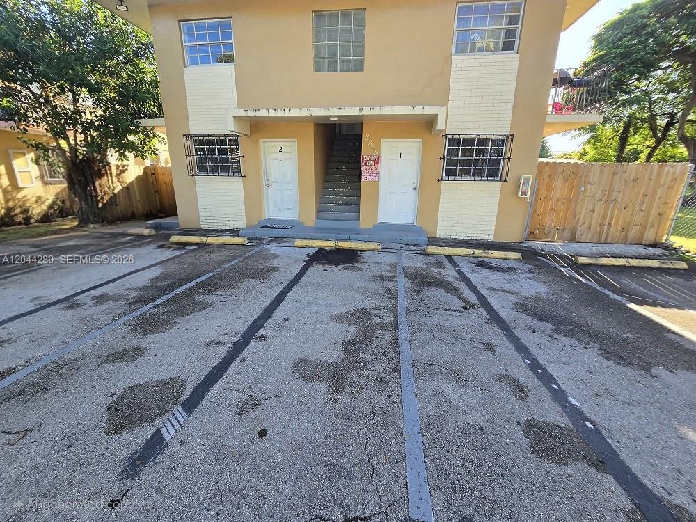 A two-story apartment building features a paved parking lot with numbered spaces in front — 2835 NW 22nd Ave, Miami FL 33142, MIAMI, FL
