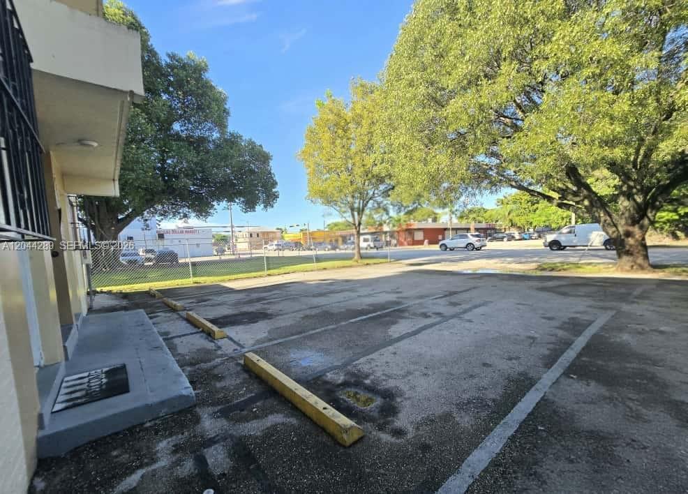 A paved parking lot with yellow wheel stops sits in front of a building exterior — 2835 NW 22nd Ave, Miami FL 33142, MIAMI, FL