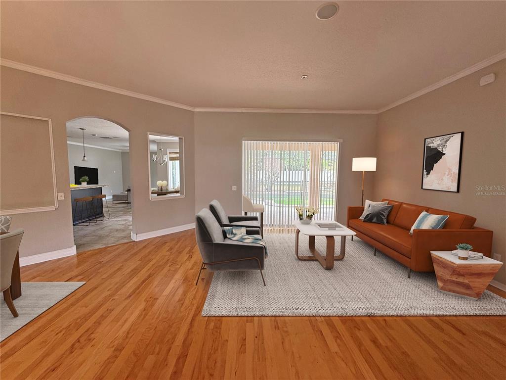 A living room with hardwood floors, a brown leather sofa, and a sliding glass door — 3045 SUTTON WOODS DRIVE, PLANT CITY, FL