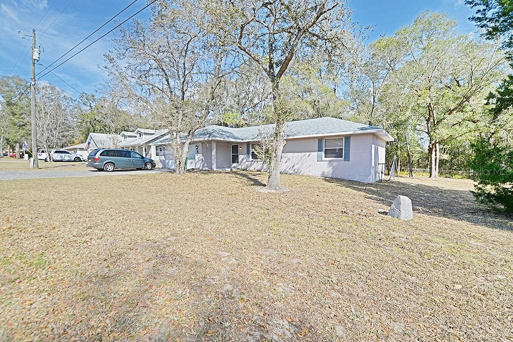 A single-story house with a light-colored exterior sits on a large, grassy lot — 5025 S HUMMINGBIRD AVENUE, INVERNESS, FL