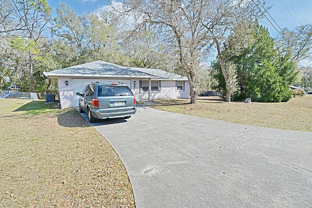 A single-story house with a concrete driveway and a parked minivan in front — 5025 S HUMMINGBIRD AVENUE, INVERNESS, FL