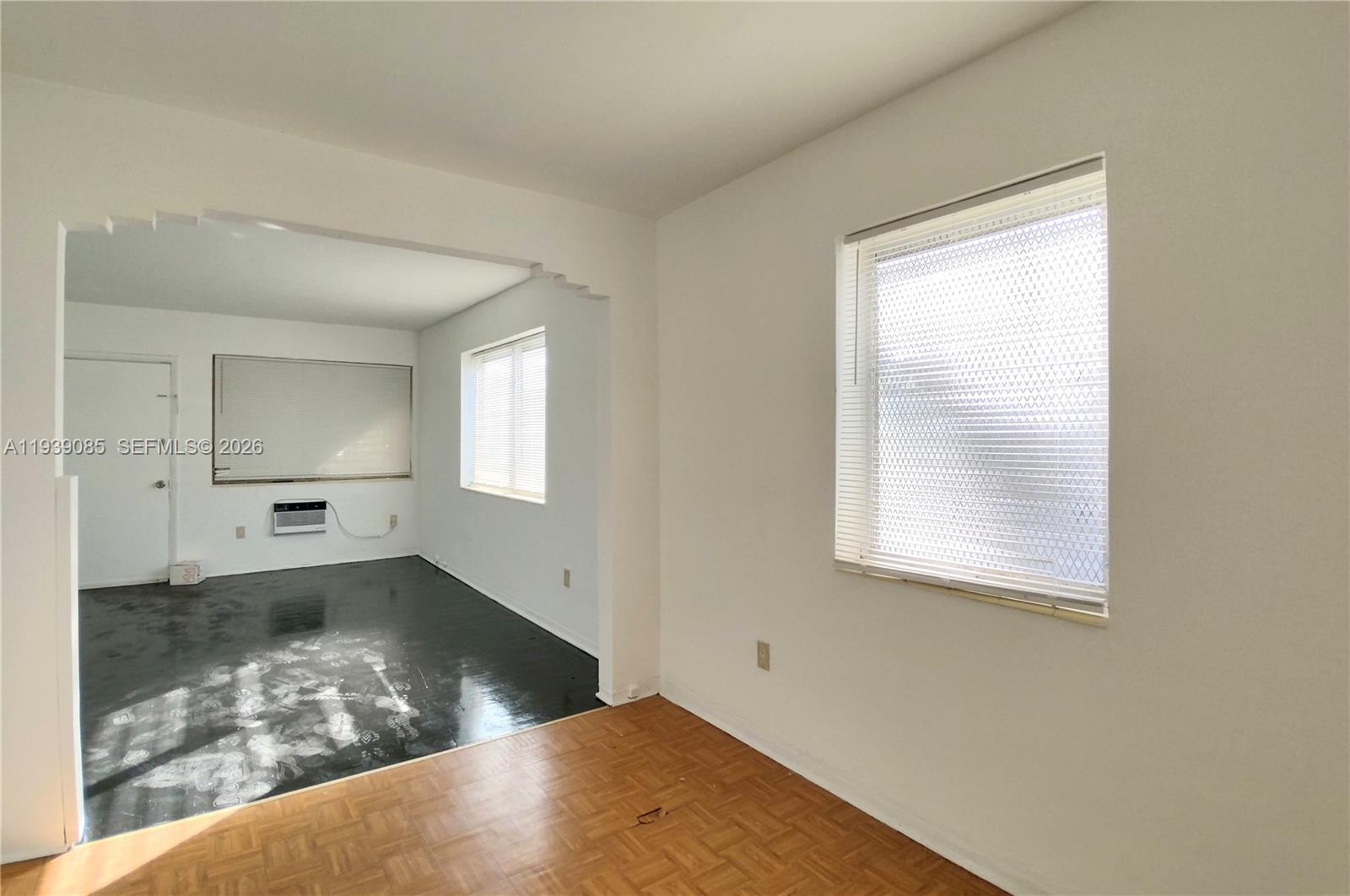 An interior view shows two connected rooms with hardwood flooring and a window with blinds — 1565 SW 6th St, Miami FL 33135, MIAMI, FL
