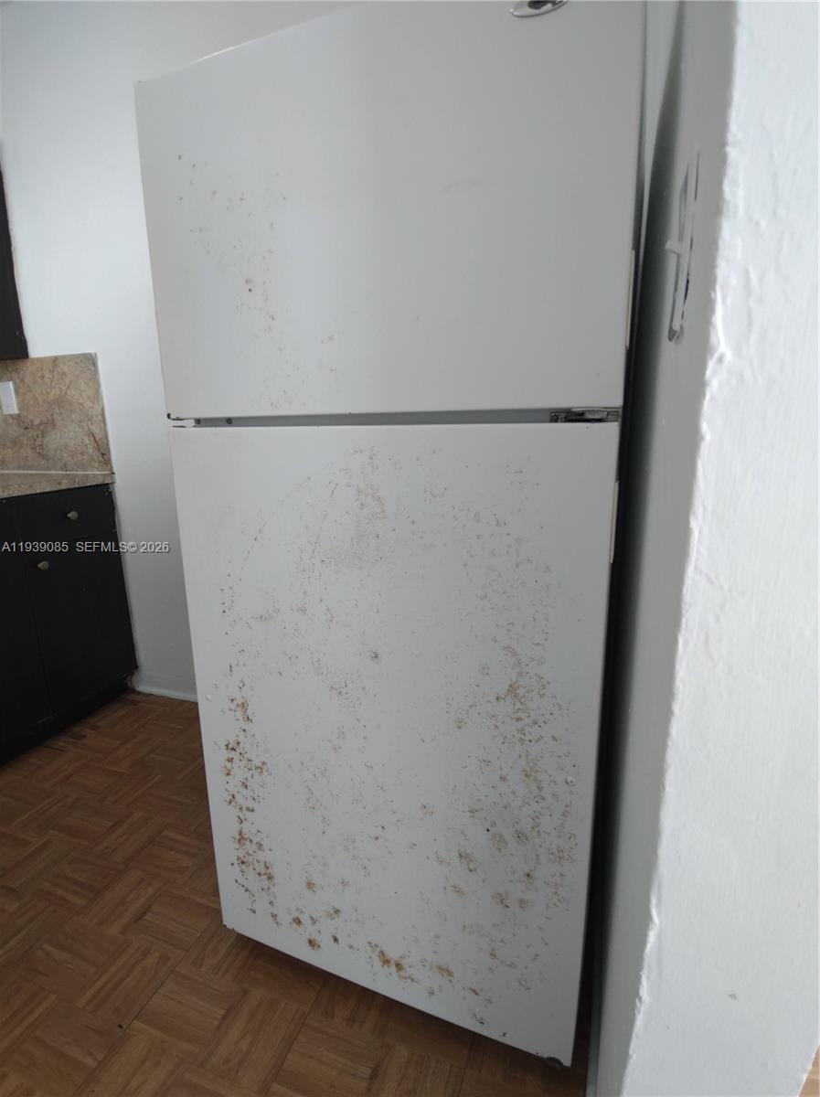 A white top-freezer refrigerator with a stained front stands in a kitchen — 1565 SW 6th St, Miami FL 33135, MIAMI, FL