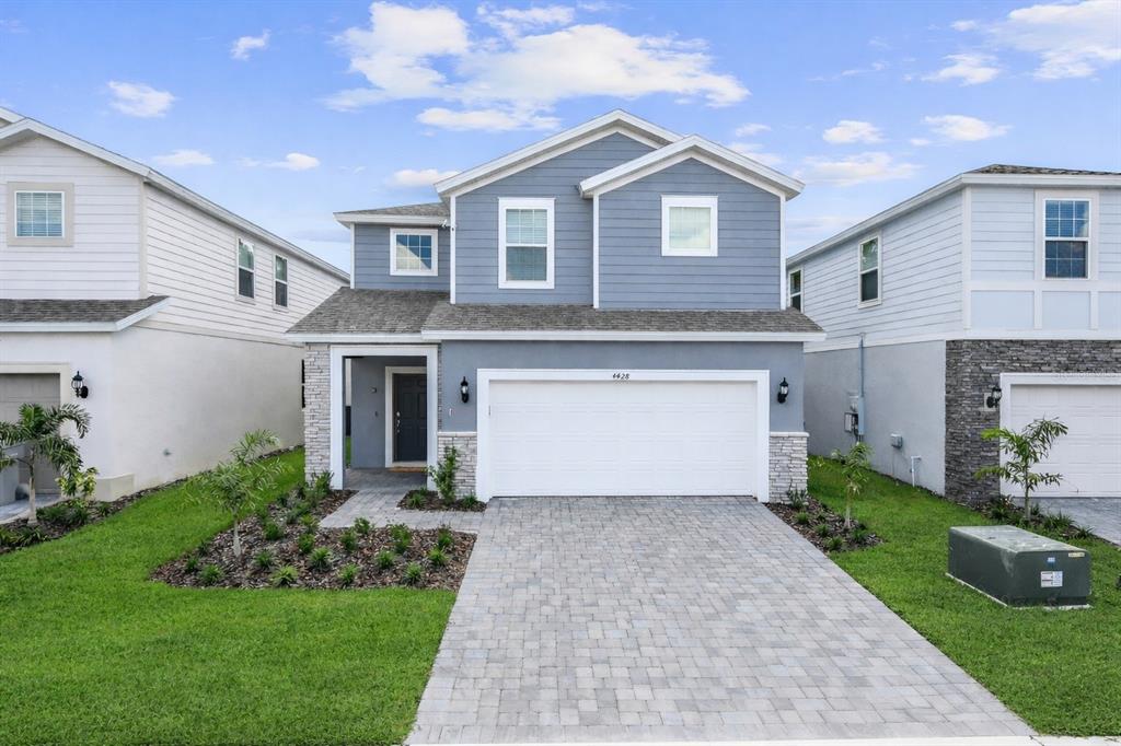 A two-story blue house with a white garage and a paved driveway — 4428 KAIPO ROAD, DAVENPORT, FL