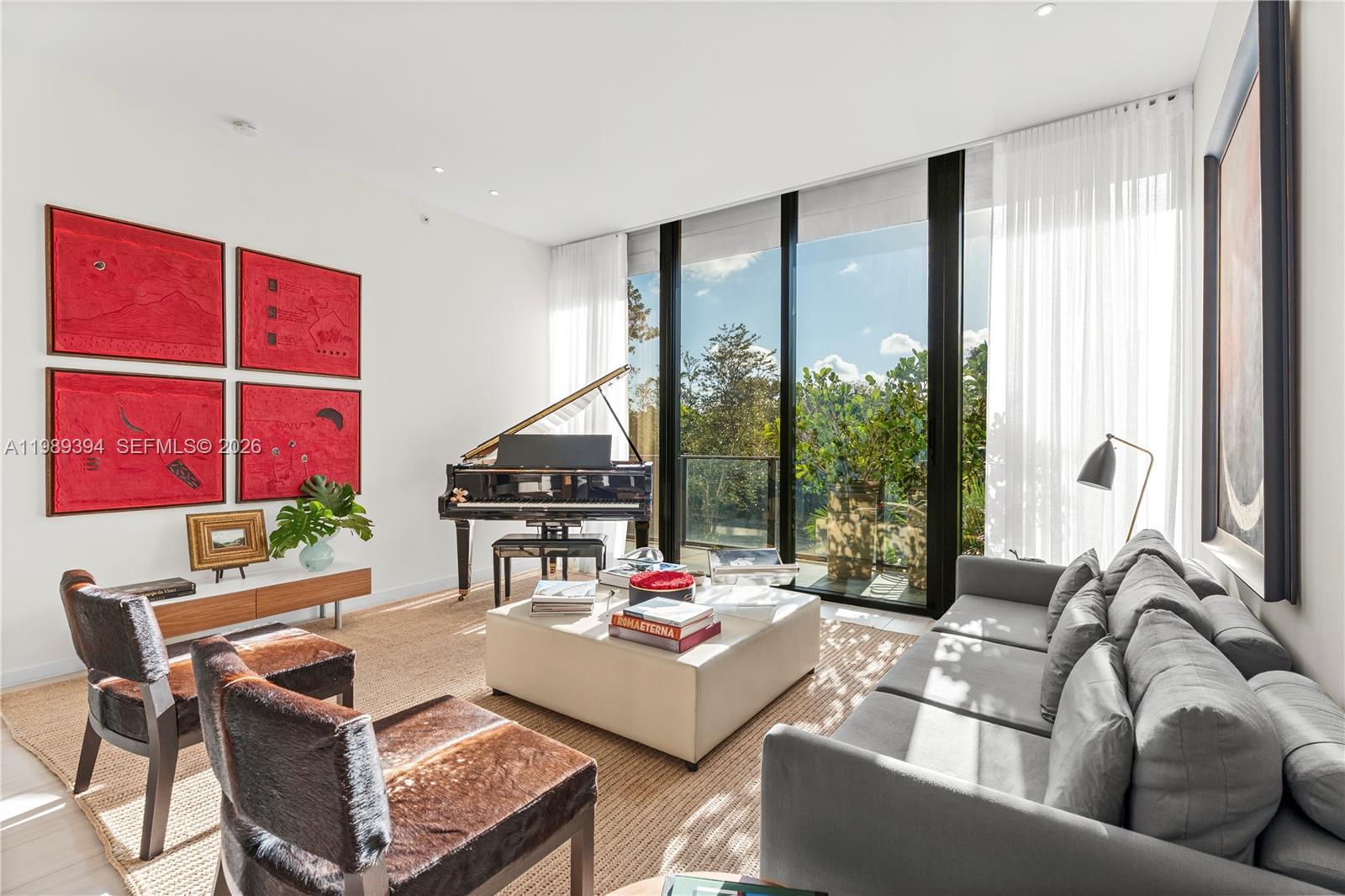 A living room features a grand piano, a gray sofa, and floor-to-ceiling windows — 3156 SW 27th Ave # 202, Miami FL 33133, MIAMI, FL