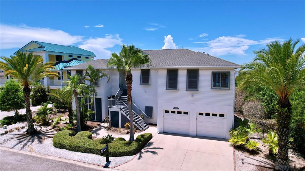 A two-story white house with a two-car garage and palm trees in the front yard — 511 SEAVIEW DRIVE, TARPON SPRINGS, FL