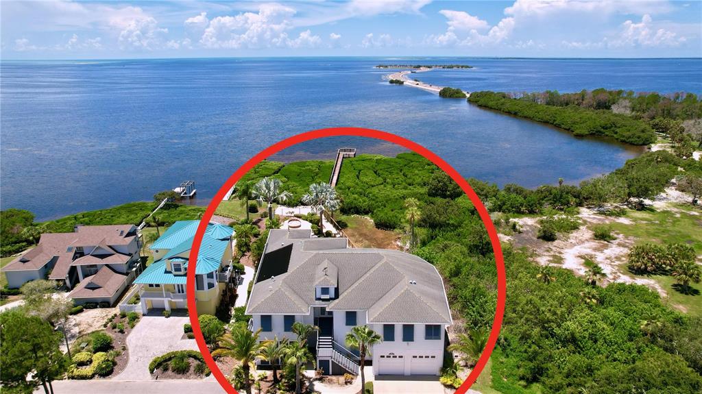 An aerial view shows a white two-story house with a gray roof near the water — 511 SEAVIEW DRIVE, TARPON SPRINGS, FL