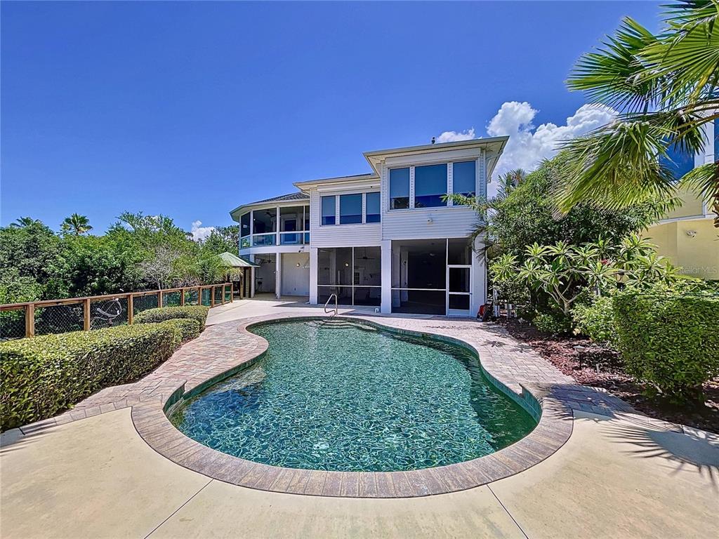A two-story house with a screened-in porch and a kidney-shaped swimming pool in the backyard — 511 SEAVIEW DRIVE, TARPON SPRINGS, FL