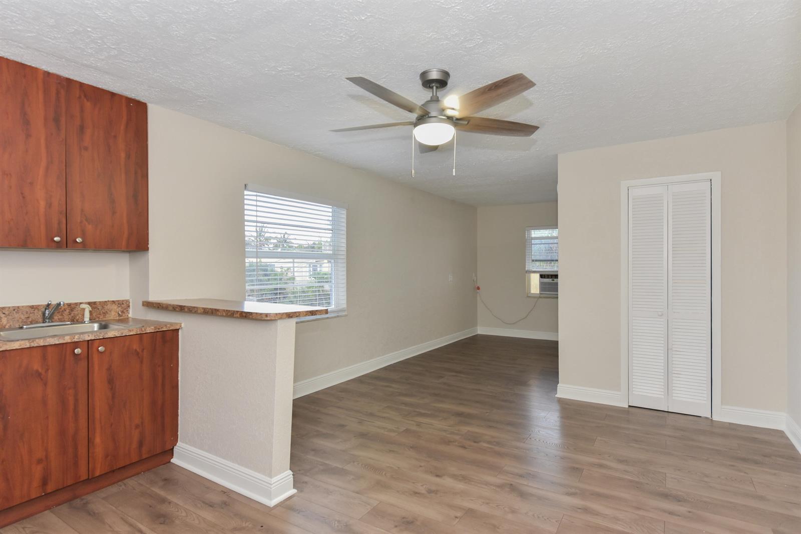 A kitchen with wood cabinets and a breakfast bar opens into a living area — 605 N Federal Highway # 9, FL 33460, FL