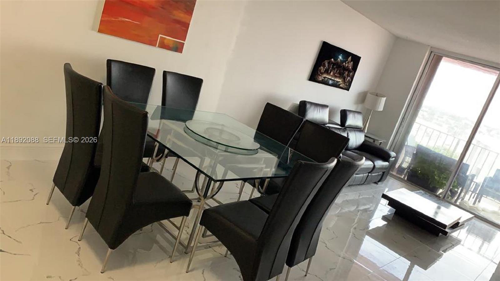 A dining area features a glass table with black chairs and white marble-style flooring — 4675 W 18th Ct # 1011, Hialeah FL 33012, HIALEAH, FL