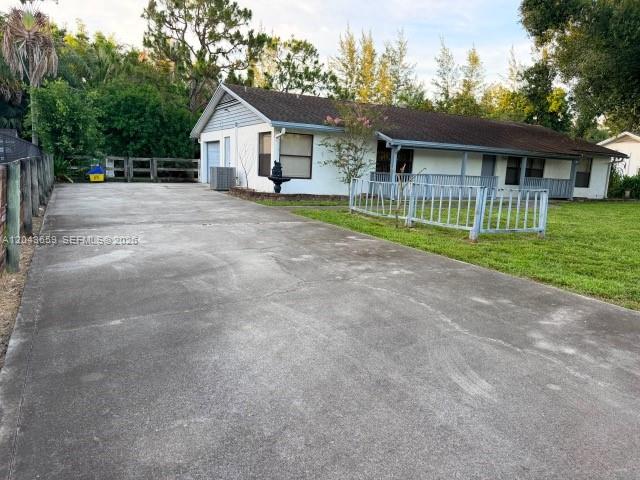 A long concrete driveway leads to a single-story white house with a brown roof — 14661 Flamingo Rd, Loxahatchee FL 33470, LOXAHATCHEE, FL