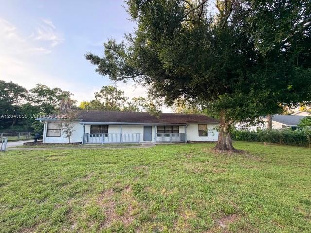A single-story house with a covered front porch sits behind a large tree — 14661 Flamingo Rd, Loxahatchee FL 33470, LOXAHATCHEE, FL