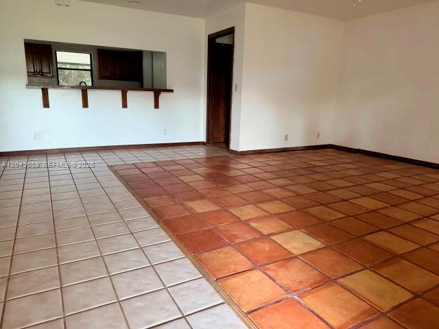 An interior view shows a room with a kitchen pass-through and two-toned tile flooring — 14661 Flamingo Rd, Loxahatchee FL 33470, LOXAHATCHEE, FL