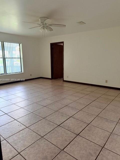 An empty room features light-colored tile flooring, a ceiling fan, and a doorway — 14661 Flamingo Rd, Loxahatchee FL 33470, LOXAHATCHEE, FL