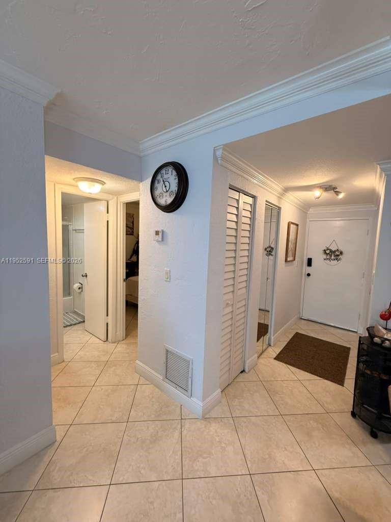 A tiled hallway leads to a front door, a bathroom, and a closet with shutters — 5501 NW 7th St # E207, Miami FL 33126, MIAMI, FL