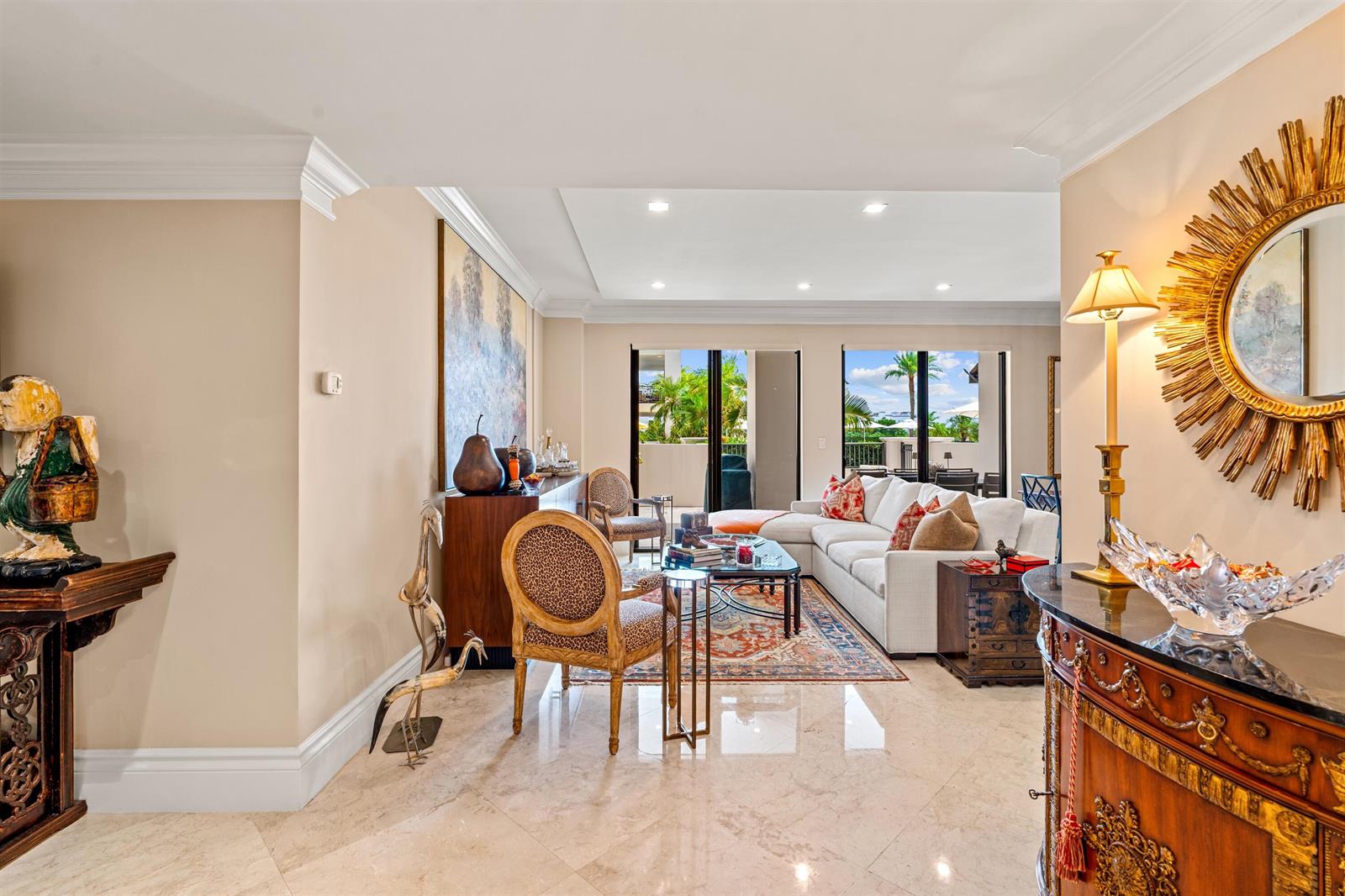A living room with light tile floors, a white sectional sofa, and a sunburst mirror — 200 E Palmetto Park Road # 404, Boca Raton FL 33432, BOCA RATON, FL