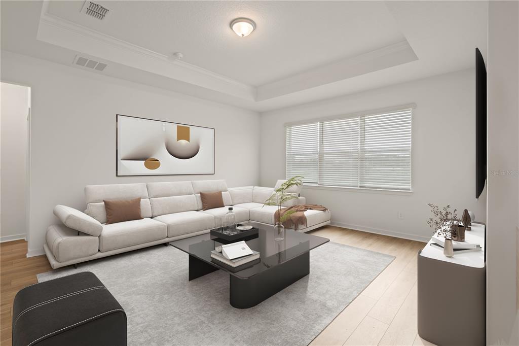 A living room features a white sectional sofa, a glass coffee table, and a tray ceiling — 11226 SYCAMORE GLEN LOOP, THONOTOSASSA, FL