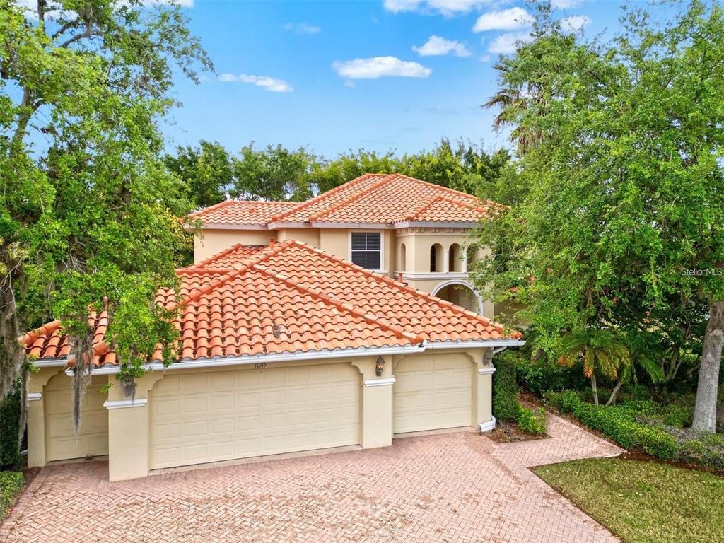 A two-story house with a terracotta tile roof and a three-car garage — 10115 DAY LILY COURT, BRADENTON, FL