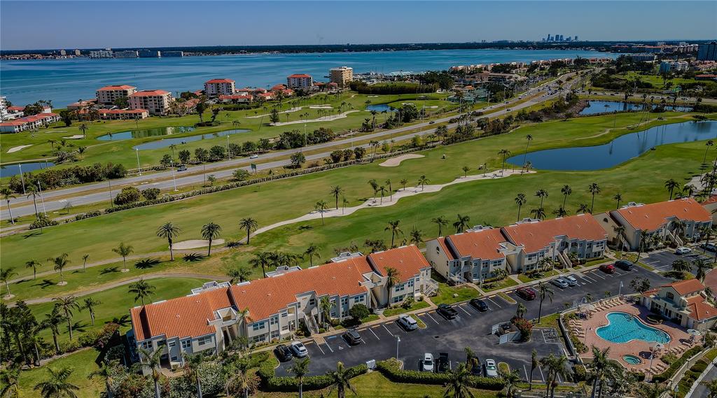 An aerial view shows a multi-unit residential complex with a pool next to a golf course — 6191 BAHIA DEL MAR BOULEVARD UNIT 103, ST PETERSBURG, FL