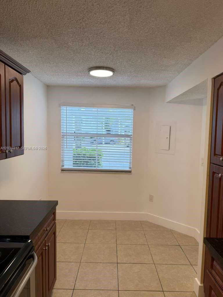 A kitchen breakfast nook with tile flooring, white walls, and a window with blinds — 9767 NW 46th Ter # 109, Doral FL 33178, DORAL, FL