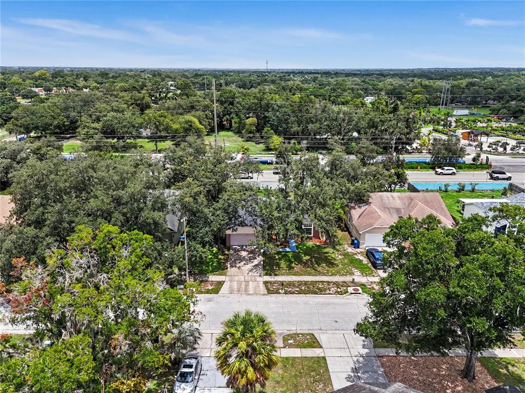 An aerial view shows a residential street with houses, driveways, and surrounding trees — 12108 FRUITWOOD DRIVE, RIVERVIEW, FL