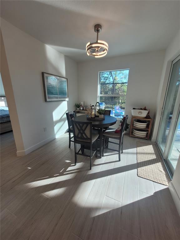 A dining area features a round table, four chairs, light wood-look flooring, and a ceiling fan — 67 SUCCESS DRIVE, PUNTA GORDA, FL