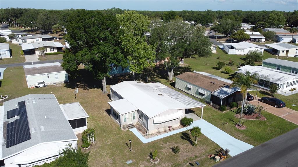 An aerial view shows a light-colored mobile home with a metal roof and carport — 449 TIVOLI PARK DRIVE, DAVENPORT, FL