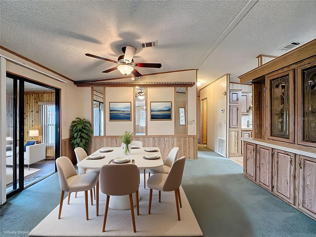 A dining room with a white table, six chairs, wood paneling, and a built-in hutch — 449 TIVOLI PARK DRIVE, DAVENPORT, FL