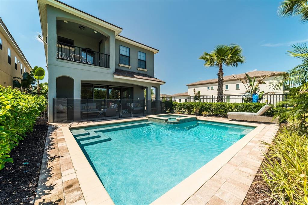 A two-story house with a backyard swimming pool, spa, and a covered patio area — 945 DESERT MOUNTAIN COURT, REUNION, FL
