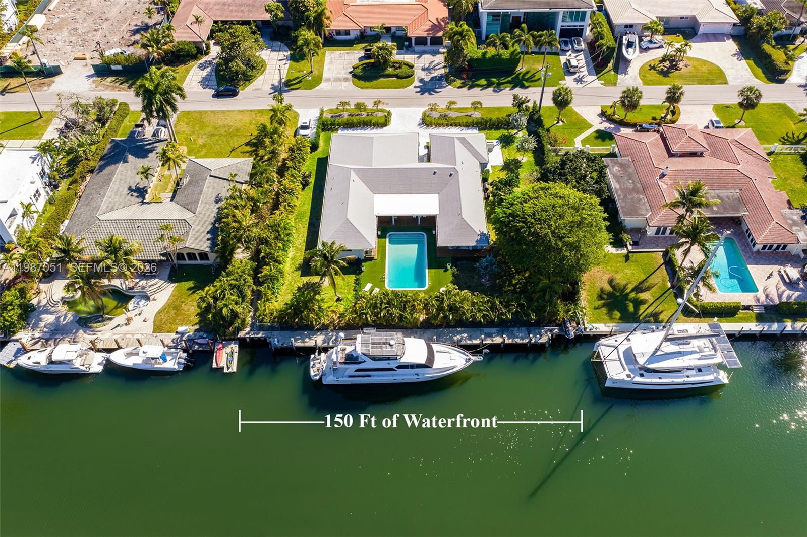 An aerial view shows a waterfront house with a swimming pool and a docked yacht — 424 Alamanda Dr, Hallandale Beach FL 33009, HALLANDALE BEACH, FL