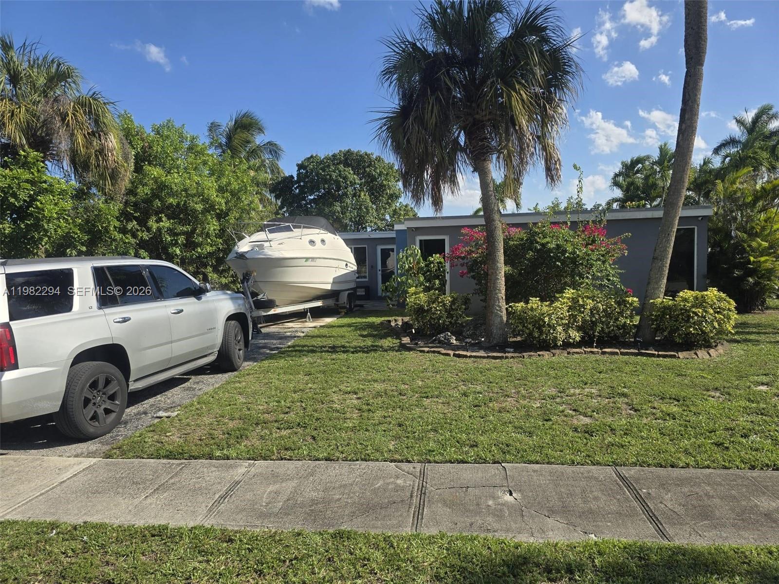 A silver SUV is parked in a driveway next to a boat and house — 5812 NW 20th Ct, Margate FL 33063, MARGATE, FL