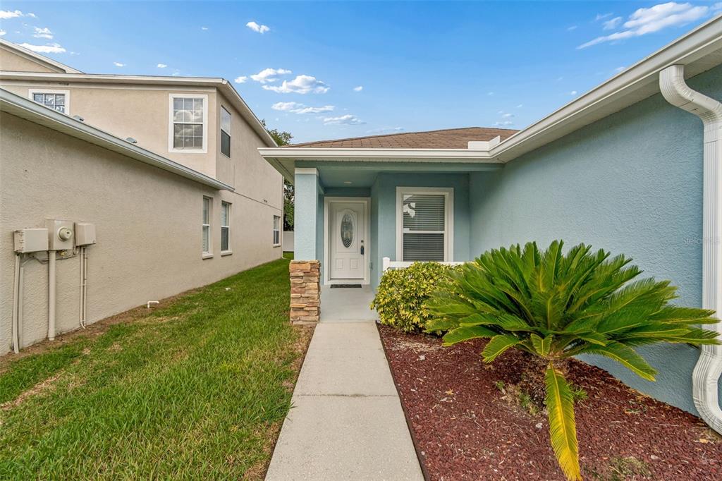 An exterior view of a single-story light blue house with a two-car garage — 10226 PERTHSHIRE CIRCLE, LAND O LAKES, FL