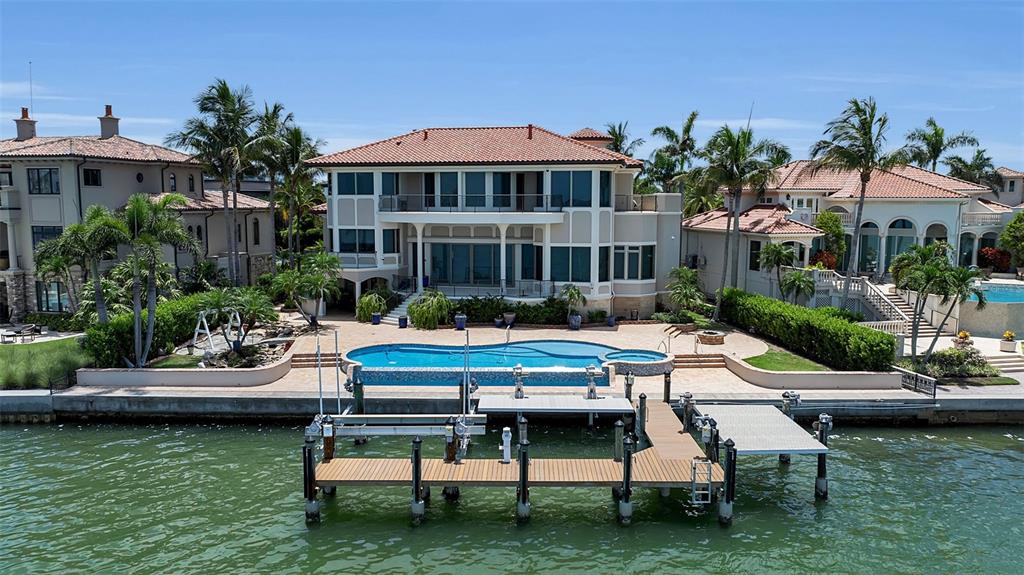 A spacious living room features high ceilings, a grand staircase, and large windows overlooking water — 1372 HARBOR DRIVE, SARASOTA, FL