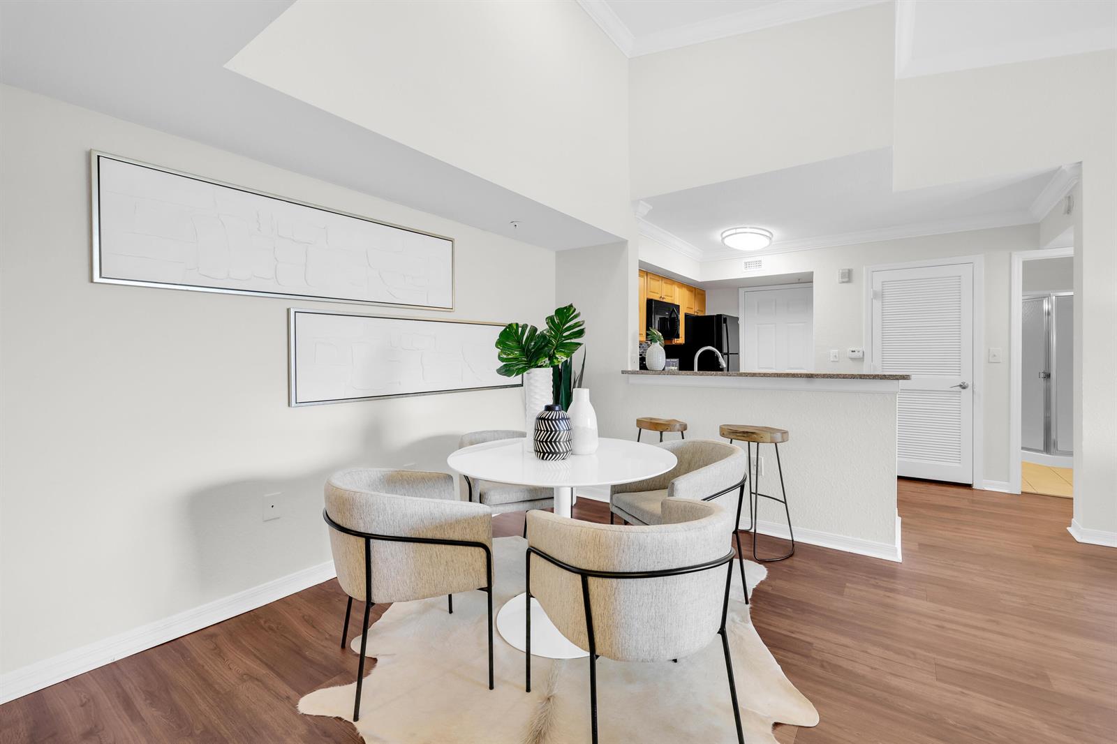 A dining area with a round white table, four chairs, and a kitchen breakfast bar — 15035 Michelangelo Boulevard # 303, Delray Beach FL 33446, DELRAY BEACH, FL