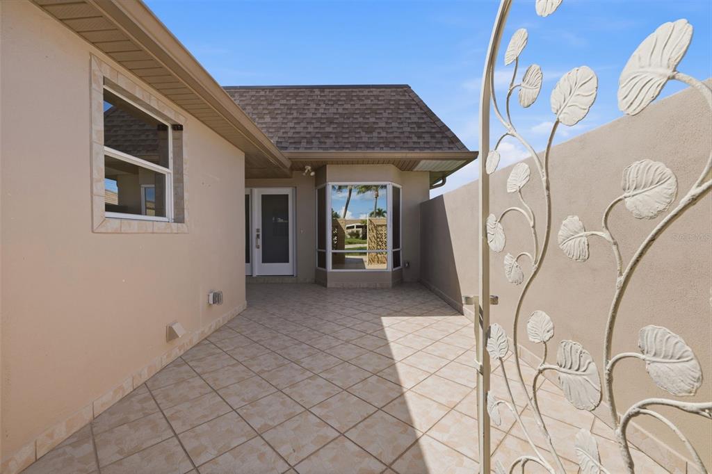 A tiled patio area features a beige exterior wall, a glass door, and a bay window — 594 BOCA CIEGA POINT BOULEVARD N, ST PETERSBURG, FL