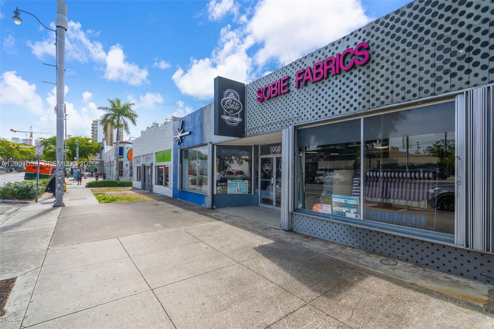 A street-level view of a commercial building with a grey polka-dot facade and signage — 1000 SW 8th St, Miami FL 33130, MIAMI, FL