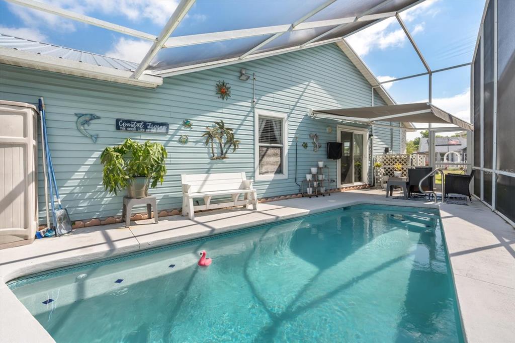 A screened-in swimming pool patio features light blue siding, a white bench, and decor — 988 DEER SPRINGS ROAD, PORT ORANGE, FL