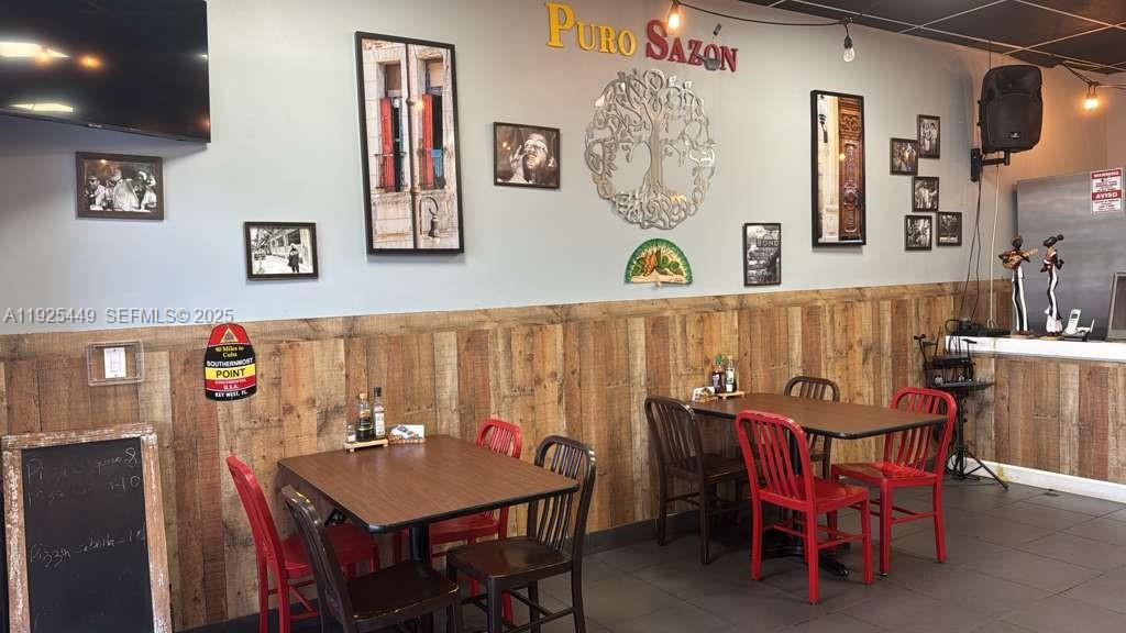 A restaurant dining area features wooden wainscoting, red chairs, tables, and wall art — 22069 S Dixie Hwy, Miami FL 33170, MIAMI, FL