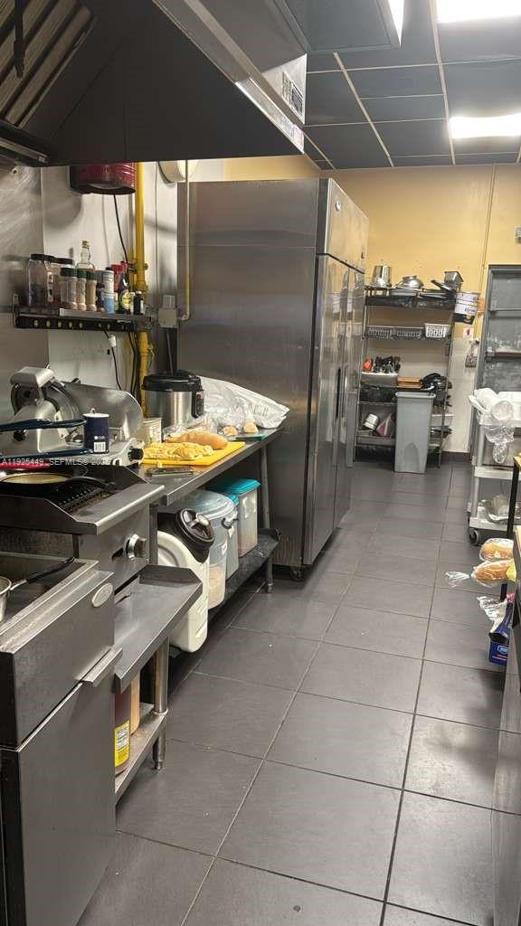 This commercial kitchen features stainless steel appliances, a prep counter, and tiled flooring — 22069 S Dixie Hwy, Miami FL 33170, MIAMI, FL