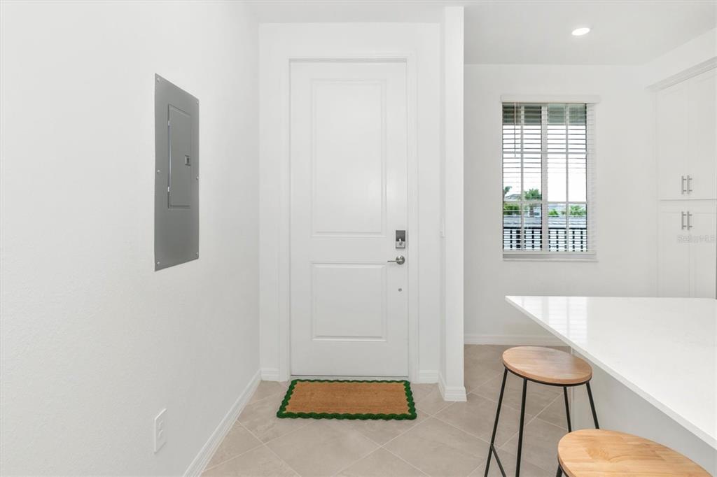 A white door with a brown mat stands in a room with tile flooring — 12320 WELLEN GOLF STREET UNIT 204, VENICE, FL