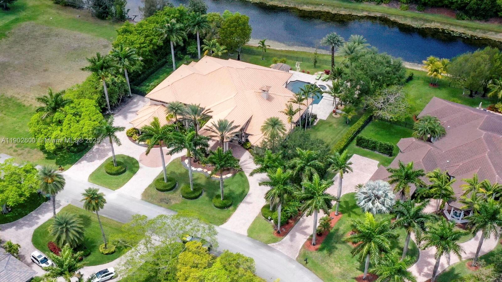An aerial view shows a large house with a tile roof, pool, and palm trees — 3828 Pine Lake Dr, Weston FL 33332, WESTON, FL