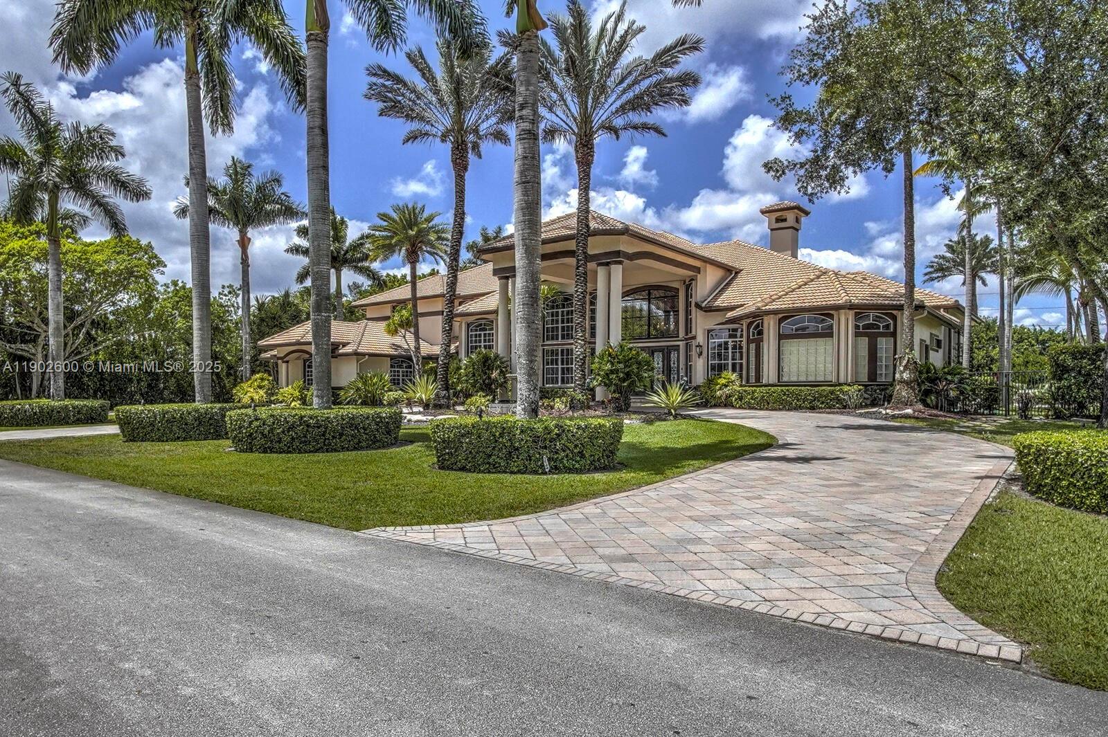A large two-story house with a tiled roof and a paved driveway surrounded by palms — 3828 Pine Lake Dr, Weston FL 33332, WESTON, FL