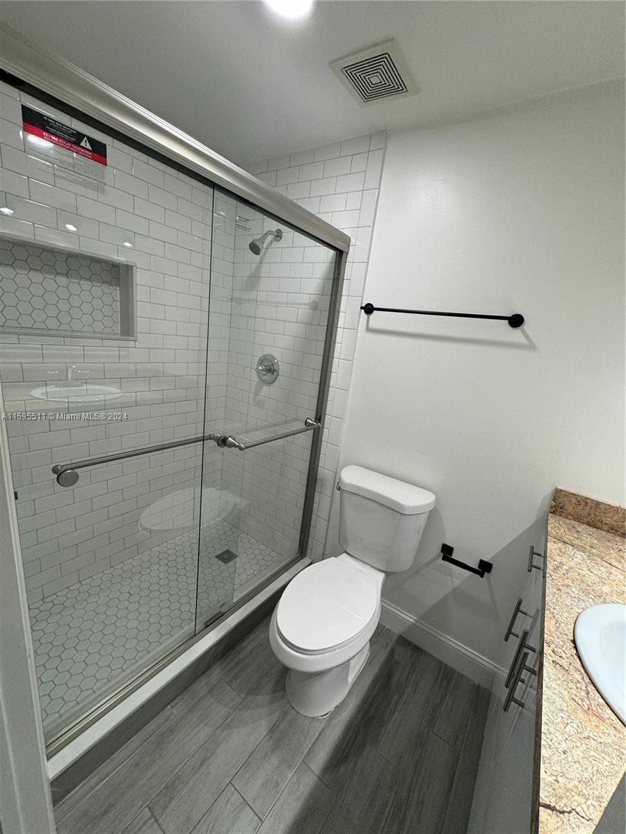 A bathroom features a glass-enclosed shower with white subway tiles, a toilet, and a vanity — 2050 SW 122nd Ave # 22, Miami FL 33175, MIAMI, FL