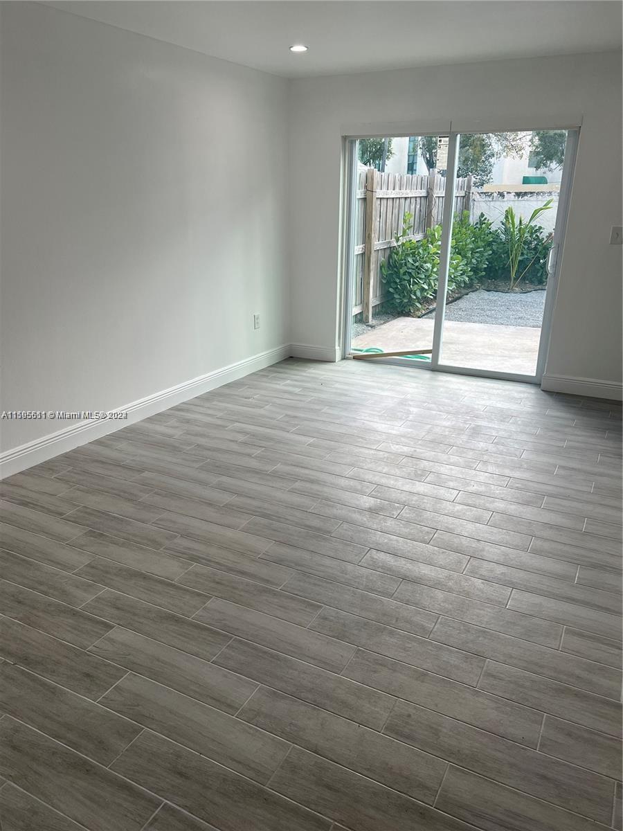 A room with light gray wood-look tile flooring and a sliding glass door to a patio — 2050 SW 122nd Ave # 22, Miami FL 33175, MIAMI, FL