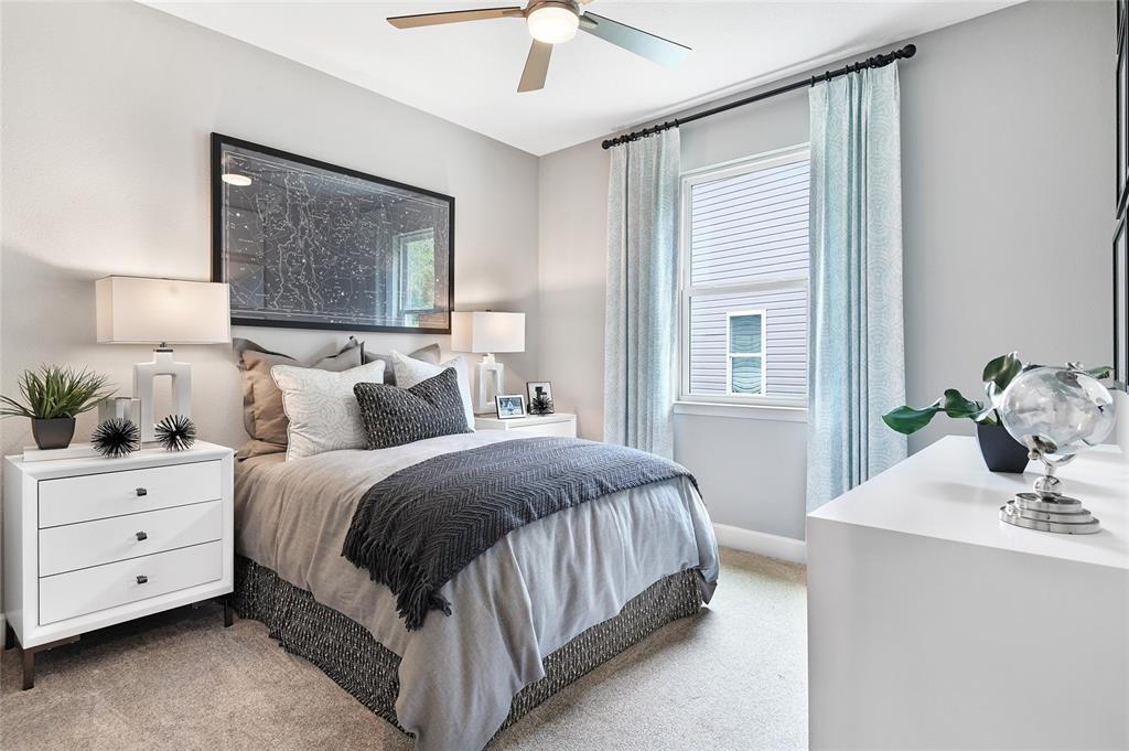 A bedroom features a bed with grey bedding, two white nightstands, and light blue curtains — 17148 LEGACY PRESERVE DRIVE, PARRISH, FL