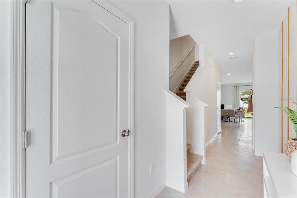 A bright entryway features a white door, a carpeted staircase, and tiled flooring — 2634 OLYMPIC COURT, DAVENPORT, FL