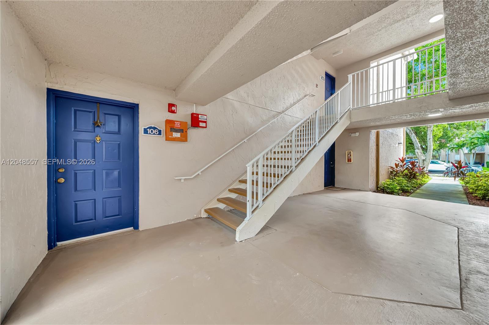 An open living area features light-colored tile flooring, gray walls, and a sliding glass door — 15770 SW 106th Ter # 106, Miami FL 33196, MIAMI, FL