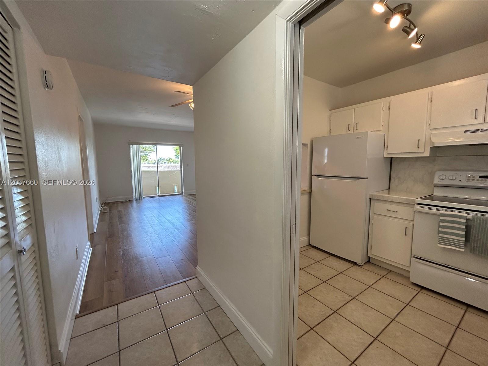 A tiled entryway leads to a kitchen on the right and a wood-floored living area — 7505 SW 82nd St # 320, Miami FL 33143, MIAMI, FL