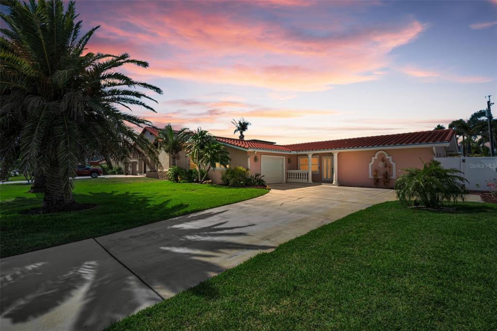 A single-story peach-colored house with a red tile roof and a concrete driveway — 111 17TH STREET, BELLEAIR BEACH, FL